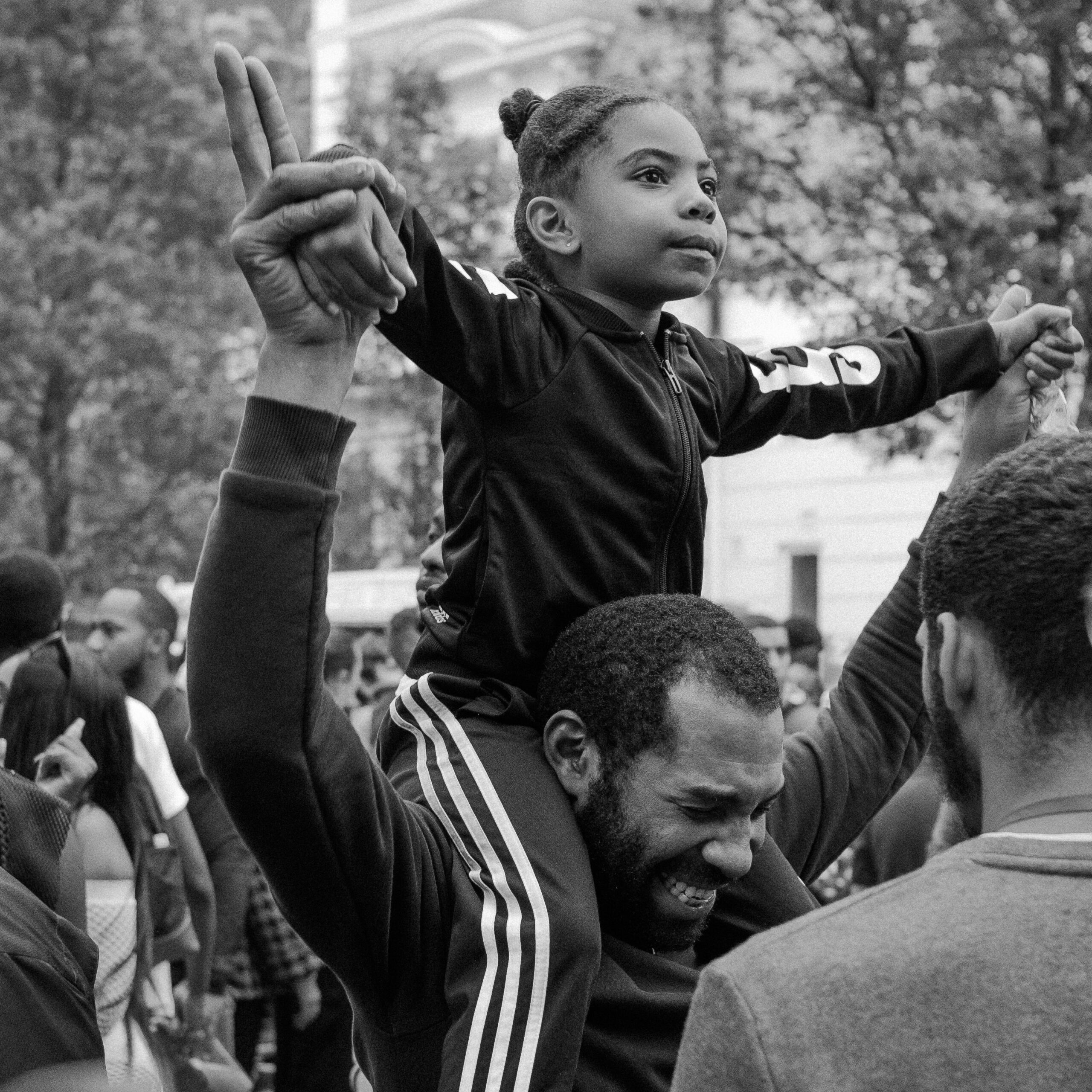 niña sobre los hombros de su padre disfrutando un festival de música en familia